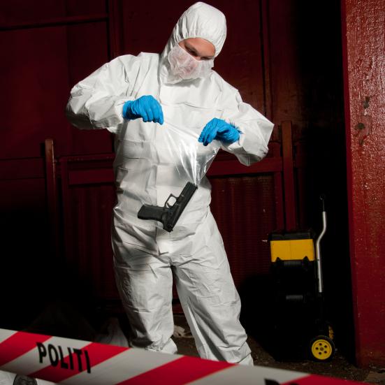 Kriminalteknikker pakker pistol som bevismateriale på gerningsstedet. Krimi.