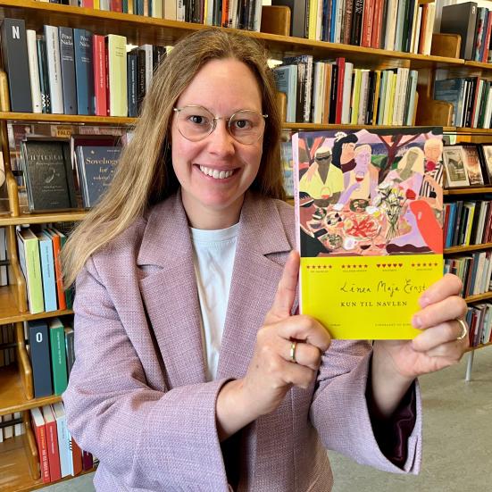 Bibliotekar Johanne Søndergaard Louv med bogen "Kun til navlen"