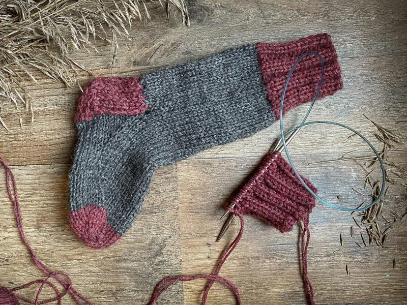 En strikket strømpe og noget garn.