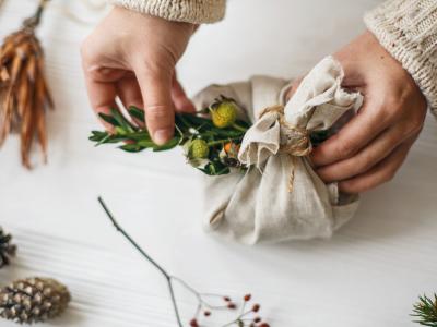 Hænder indpakker bæredygtig julegave.